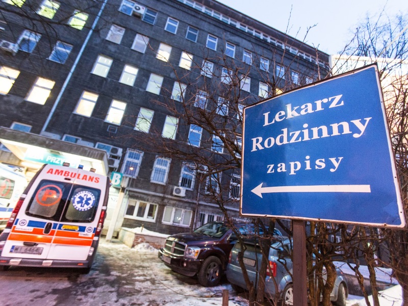 Szpital, przed nim karetka i tabliczka z napisem: lekarz rodzinny zapisy/ fot. Marta Kuśmierz