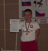 Małgorzata Hałas-Koralewska w stroju reprezentacji Polski, medalem na szyi i dyplomem w ręku
