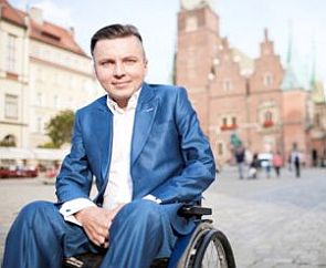 Bartłomiej Skrzyński na wózku inwalidzkim, w tle rynek we Wrocławiu
