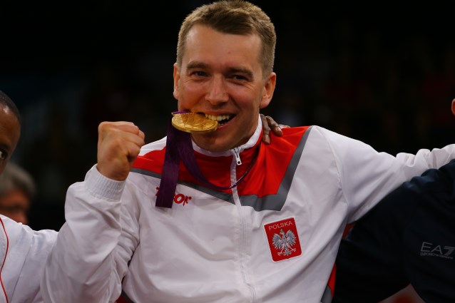 złoty medalista z niepełnosprawnością przygryza medal