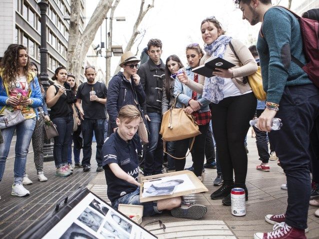 Mariusz Kędzierski rysuje obrazy na ulicy w tłumie ludzi