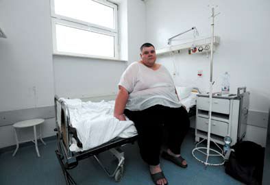 Mężczyzna z otyłością siedzi na szpitalnym łóżku