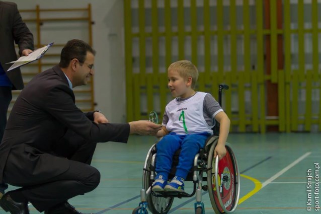 chłopiec Dawid otrzymuje szklany medal od Prezydenta Konina.