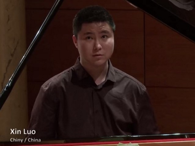 Xin Luo siedzi przy fortepianie