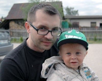 Adam Kujawa ze swoim synkiem siedzącym na kolanach