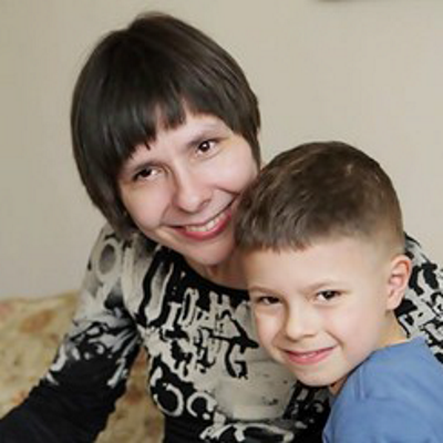 Agata Romik-Kopeć uśmiechnięta ze swoim synkiem na kolanach