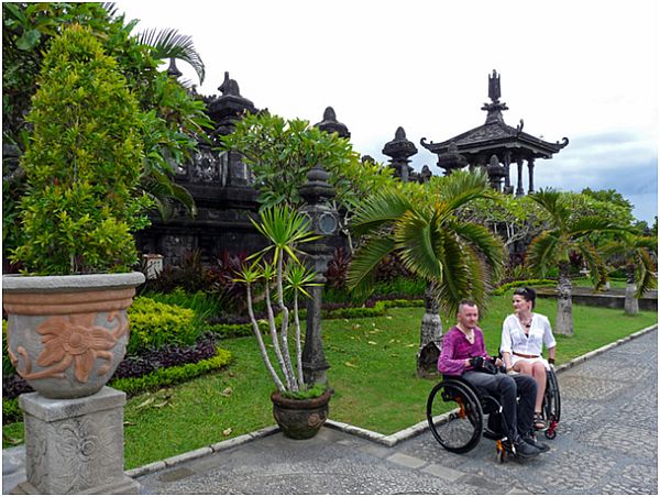 Dwie osoby na wózku wśród egzotycznej roślinności
