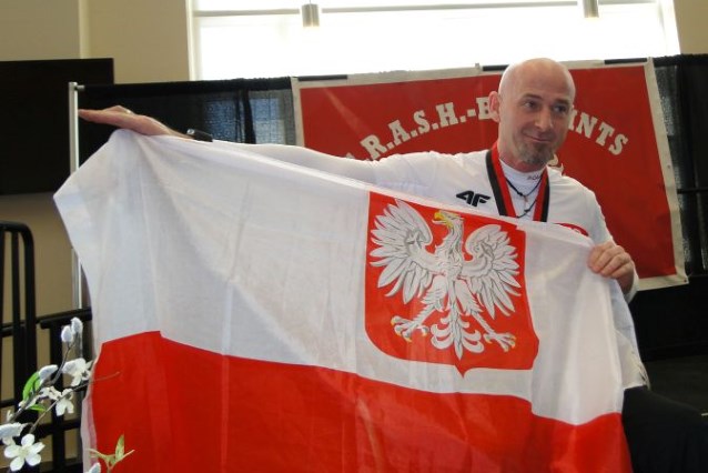 Jarosław Kailing trzyma w dłoniach flagę Polski