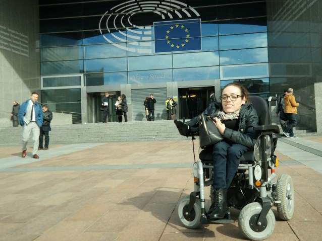 Marta Zając na tle wejścia do Parlamentu Europejskiego