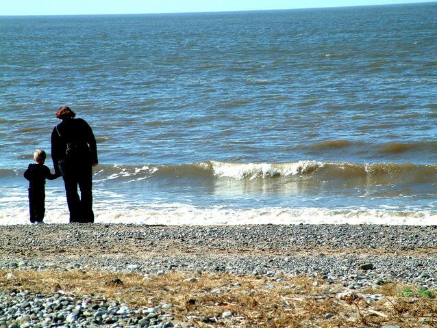 Matka z dzieckiem stoją na brzegu morza