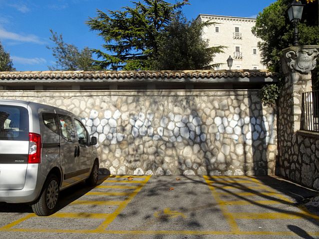 Szerokie miejsce parkingowe dla osoby z niepełnosprawnością z zaznaczonymi po bokach dodatkowymi miejscami na otwarcie drzwi
