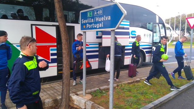 wysiadający piłkarze z autobusu, obok parkingu kierunkowskaz na Portugalię