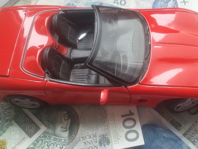 Model samochodu stoi na banknotach