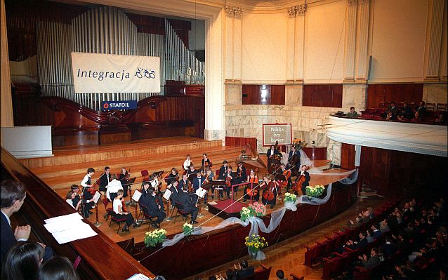 Wnętrze Filharmonii Narodowej z organami w tle i banerem Integracja, przed nią orkiestra, na pierwszym planie widzowie