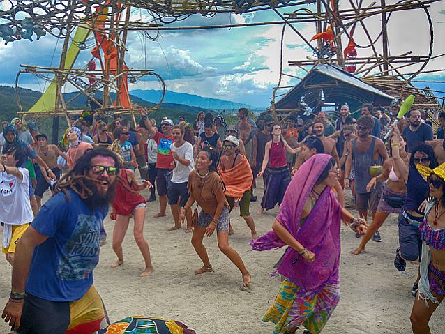 tańczący pod sceną tłum kolorowo ubranych ludzi