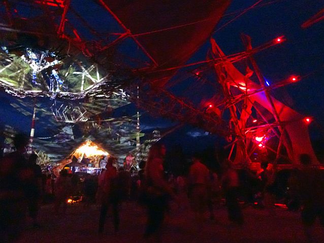 płócienne dachy na konstrukcji z bambusów, pod którymi stoją i tańczą ludzie