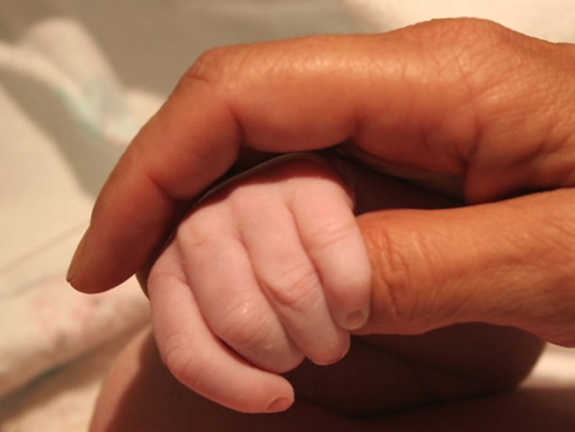 dłoń dziecka trzyma kciuk rodzica