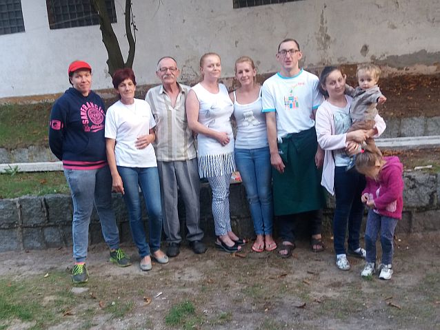 Wspólne zdjęcie siedmiorga pracowników spółdzielni socjalnej Kotwica, kobieta po prawej stoi z dwójką małych dzieci
