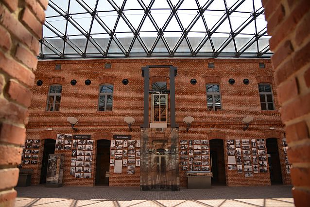 Dziedziniec muzeum. Ściany z czerwonej cegły, w którą wbudowana jest nowoczesna winda