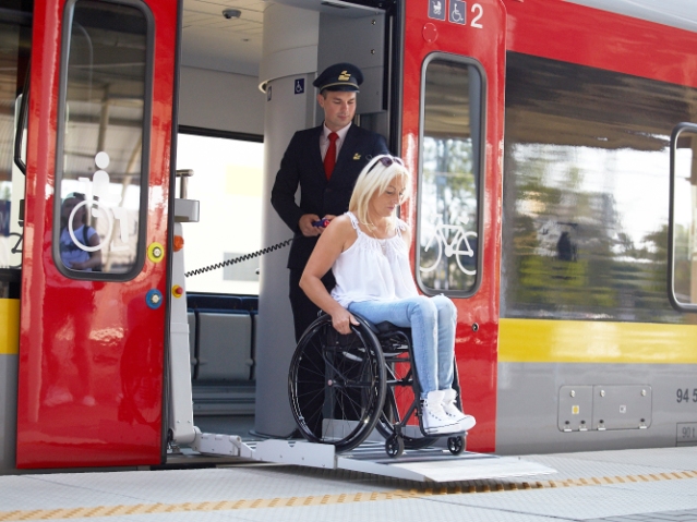kobieta na wózku wysiada z pociągu Łódzkich Kolei Aglomeracyjnej