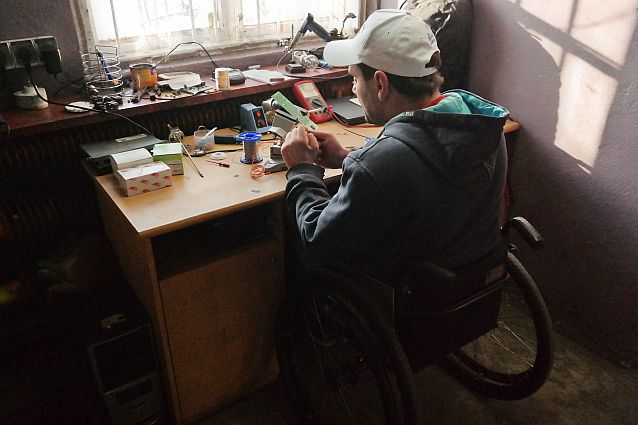 Kamil Więckiewicz naprawia sprzęt przy biurku