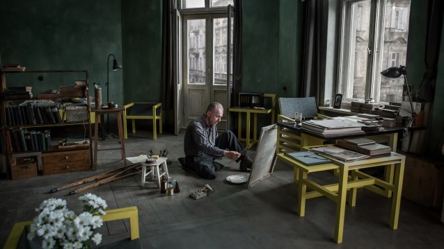 Władysław Strzemiński siedzi na podłodze i maluje