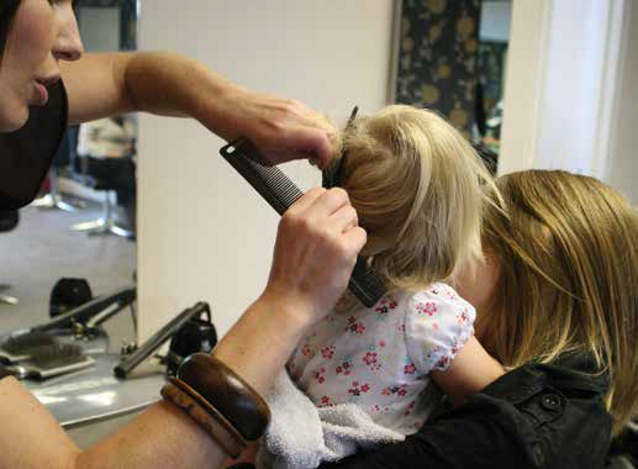 kobieta obcina włosy małej dziewczynce