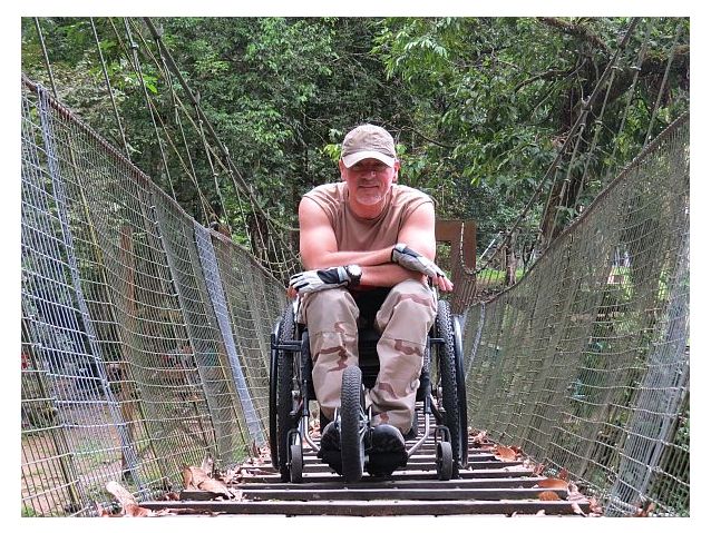 Tomasz Tasiemski na wózku na mostku w dżungli