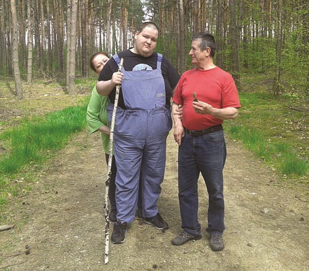 Młody mężczyzna na leśnej ścieżce podczas spaceru z rodzicami