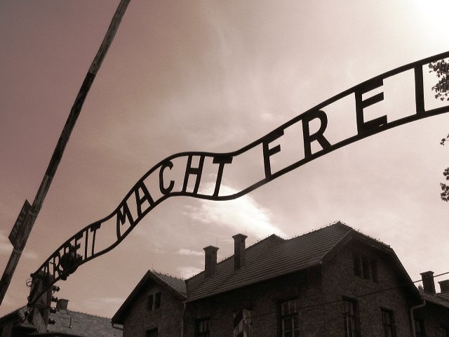 Napis na bramie wejściowej do obozu Auschwitz: Arbeit macht frei