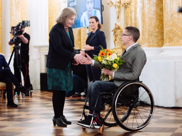Adrian Beściak odbiera kwiaty podczas gali Człowiek bez barier