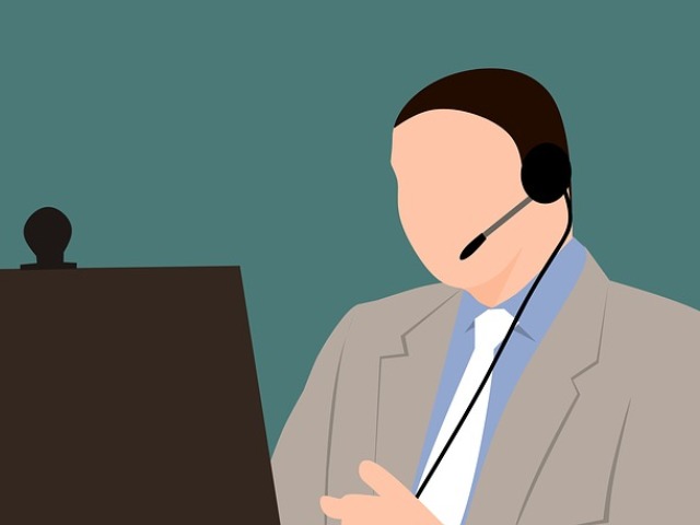 grafika mężczyzny, który pracuje jako telemarketer przed komputerem ze słuchawkami z mikrofonem