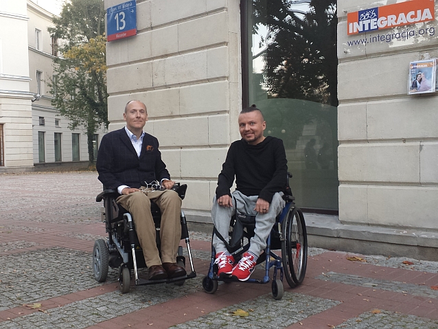 Do zdjęcia na tle siedziby Integracji pozują siedzący na wózkach Piotr Pawłowski oraz Bartłomiej Skrzyński