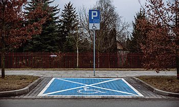 Miejsce parkingowe dla osoby z niepełnosprawnością, zlokalizowane przy chodniku