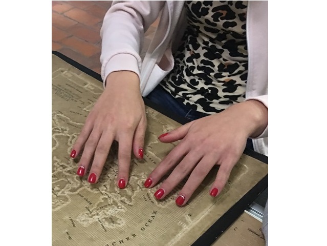 kobiece ręce z czerwonymi paznokciami dotykają starej mapy