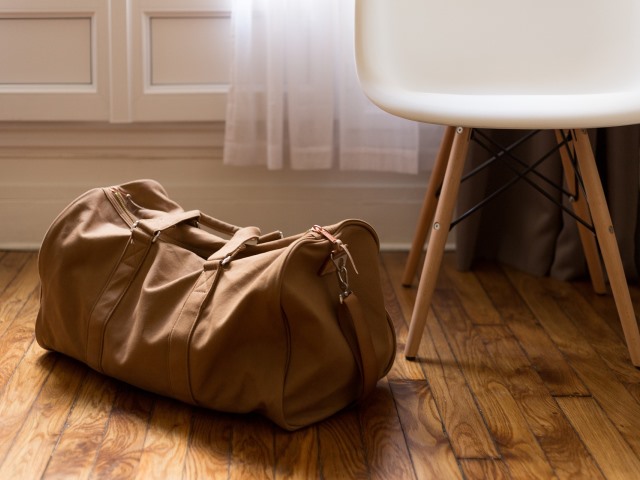torba podróżna stoi na podłodze obok krzesła