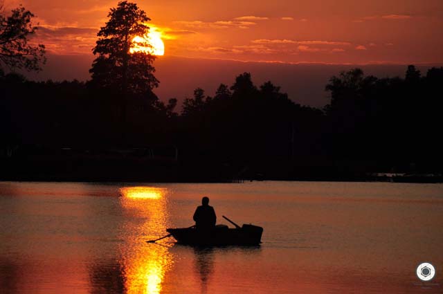 mężczyzna na łódce podczas zachodu słońca