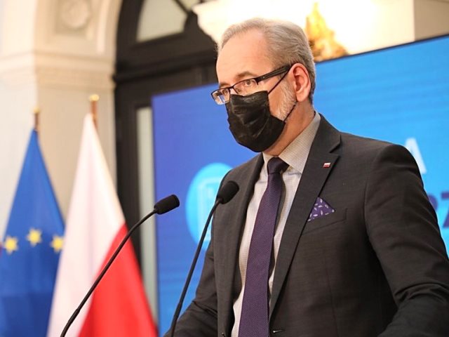 minister adam niedzielski podczas konferencji, w tle flagi polski i UE