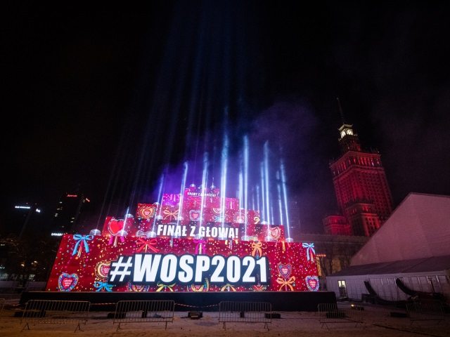 świetlna iluminacja z napisem finał z głową #wosp2021 w tle pałac kultury i nauki