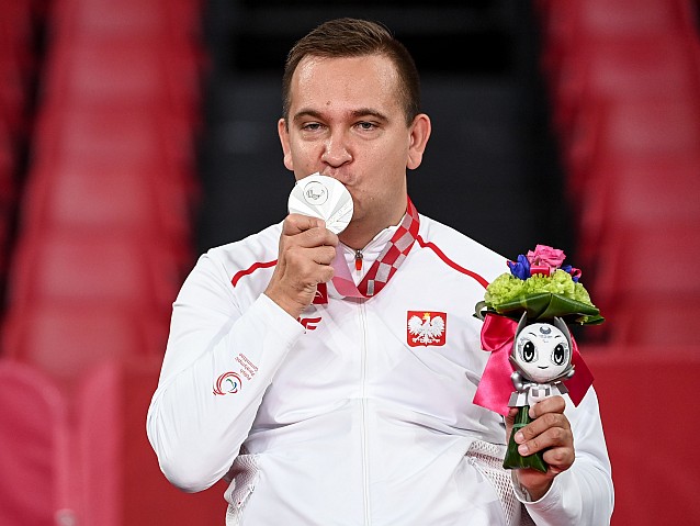 Rafał Czuper całuje zawieszony na szyi srebrny medal