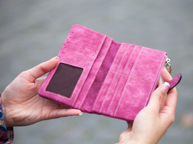 pusty różowy portfel w kobiecych rękach