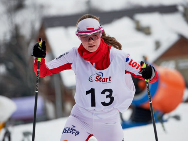 Aneta Górska w sportowych zimowych ubraniach sportowych jedzie na nartach