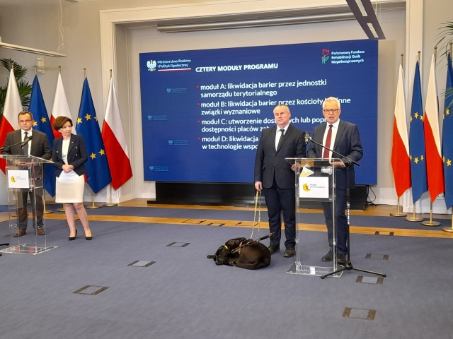 Briefing w siedzibie Ministerstwa Rodziny i Polityki Społecznej z udziałem Marleny Maląg, Krzysztofa Michałkiewicza, Pawła Wdówika i Pawła Rychlika. Za prelegentami wyświetlają się informacje na temat 4 modułów programu "Dostępna przestrzeń publiczza" 