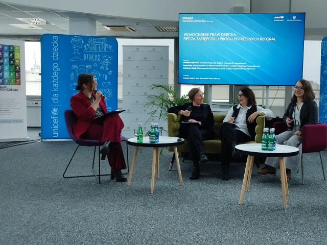 Cztery kobiety biorą udział w panelu podczas debaty Unicef i RPD. Jedną z nich jest Dominika Filipowicz z redkacji Integracji. Za nimi jest ekran, na którym wyświetlany jest napis wzmocnienie praw dziecka. piecza zastępcza u progu potrzebnych reform.