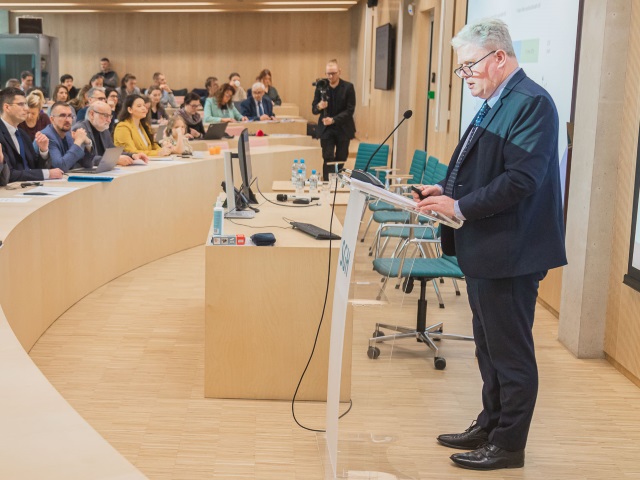 Mark Pearson, mężczyzna w średnim wieku prowadzi wykład podczas konferencji.