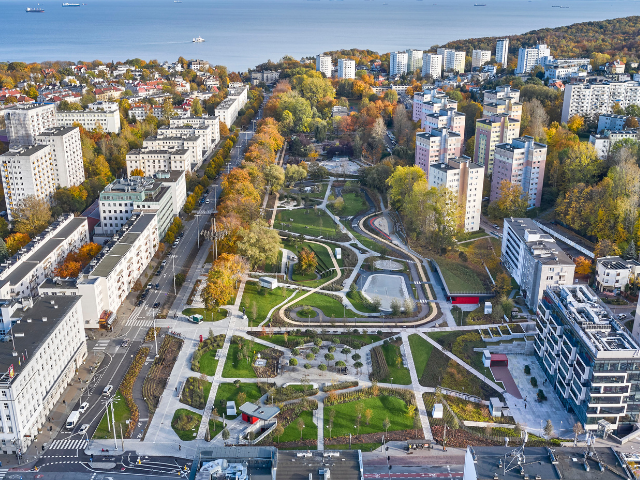 Widok z lotu ptaka na park w centrum Gdyni otoczony budynkami mieszkalnymi. 