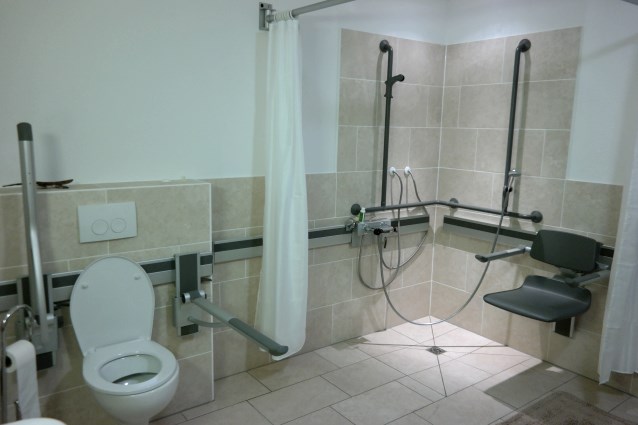 dostosowany prysznic z regulowanym krzesełkkiem