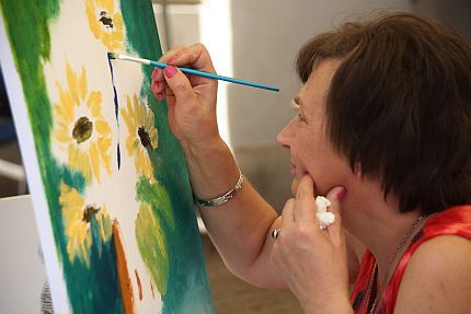 Elżbieta Łysoniewska, malująca pędzlem słoneczniki