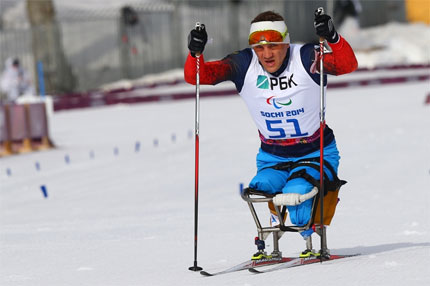Rosjanin Roman Pietuszkow na sledżu na trasie biegu narciarskiego