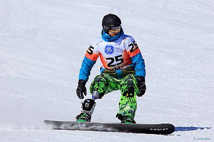 Zawodnik z protezą nogi jedzie na desce snowboardowej